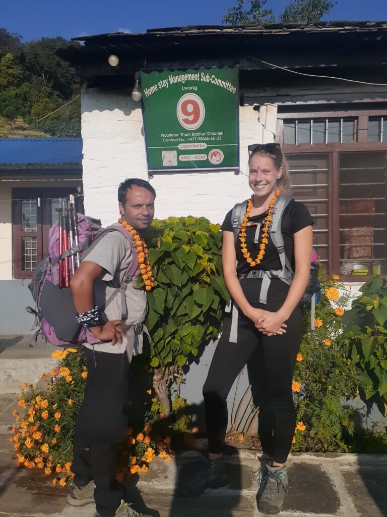 A guide and a tourist in front of a tea house in Mardi Himal Trek